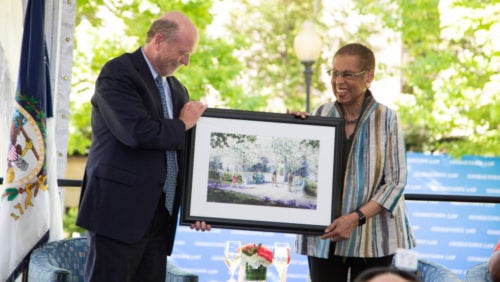 Dean William M. Treanor presents Congresswoman Eleanor Holmes Norton with an artist's depiction of a planned bench and memorial to honor Norton.
