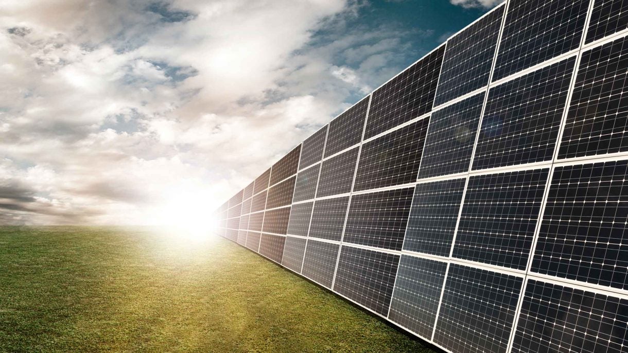 Rays of sun hitting a row of solar panels.