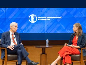 IIEL Logo prominently centered on backdrop with two speakers in the forefront.