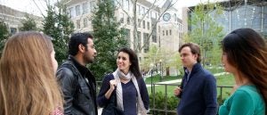 Four Georgetown Law students talking outside in front of the clock tower on the Capitol Campus.