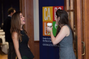 Students conversing next to CAROLA banner