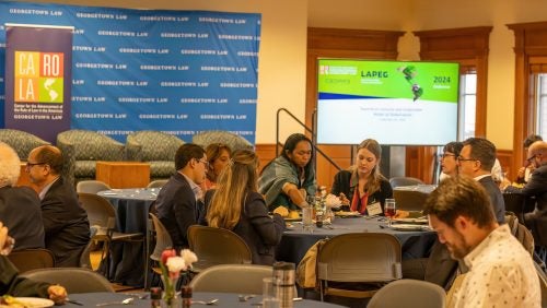 People attending the LAPEG conference are seen waiting until the next session starts.