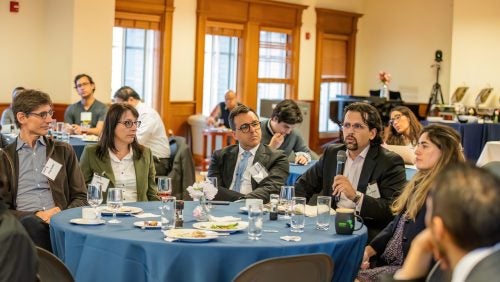 Daniel Rangel is seen asking a question while the rest of the table listens.