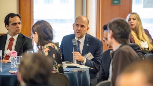 Sebastian Ortiz is seen asking a question while the rest of the table listens.