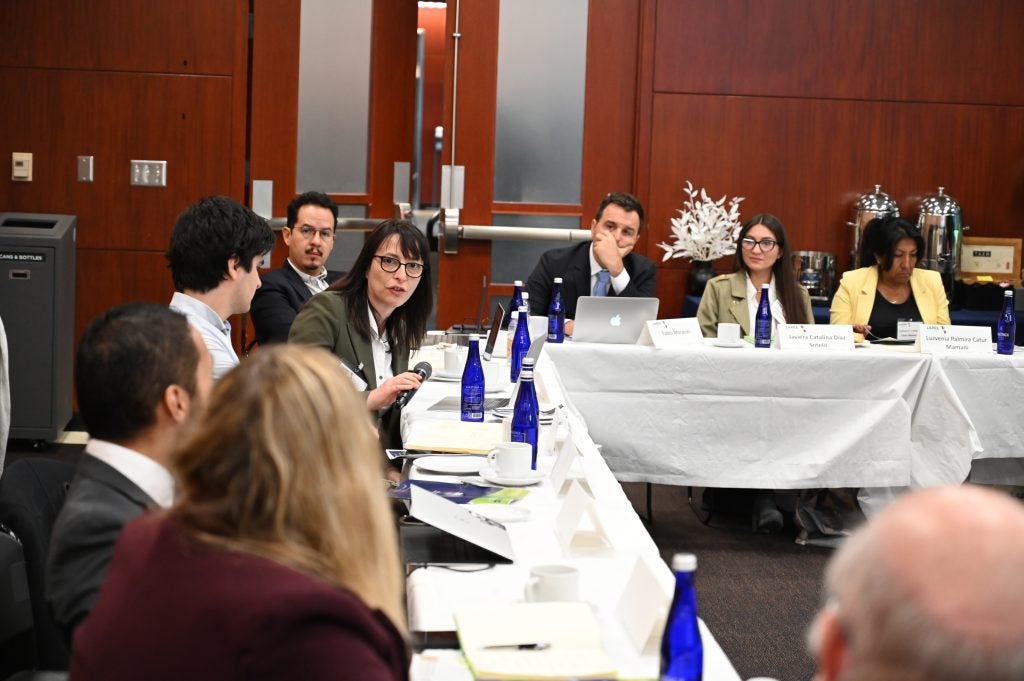 Professor Veronica Robert talking at a round table while looking at the moderator