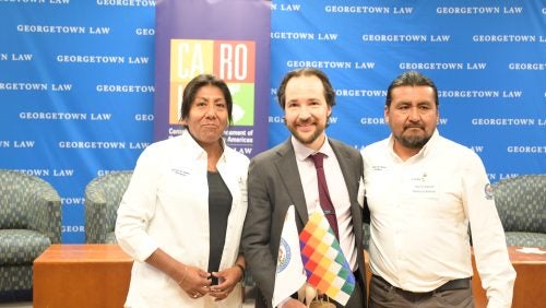 Alvaro Santos is holding a gift from the Pueblos Atacamenos. One representative of the group is at each side.