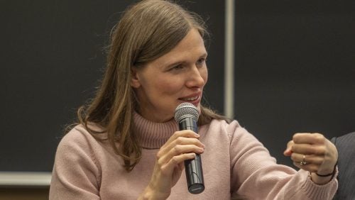 Professor Kathleen Claussen talking holding a microphone