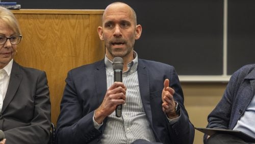 Josh Kagan speaking holding a microphone at the panel