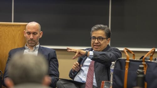Ricardo Ramirez speaking holding a microphone at the panel