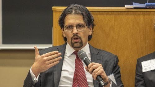Daniel Rangel speaking holding a microphone at the panel