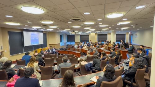 Overview of the classroom where the event took place and it shows students and other guests listening to the panel