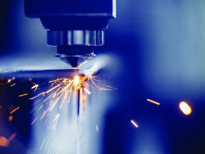 Cover photo from Industrial Policy Report, Laser CNC cutting of metal with light spark, modern industrial technology. Blue color steel tool