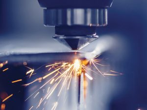 Cover photo from Industrial Policy Report, Laser CNC cutting of metal with light spark, modern industrial technology. Blue color steel tool