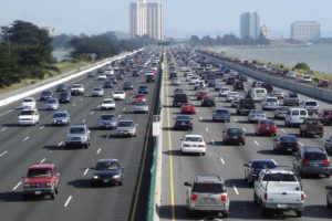 Cars in traffic on a highway near a body of water 