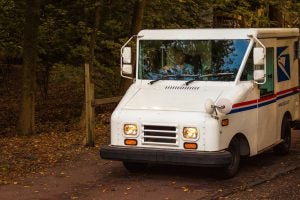 A USPS letter carrier drives a Grumman LLV mail truck. Photo by Petr Kratchovil. 