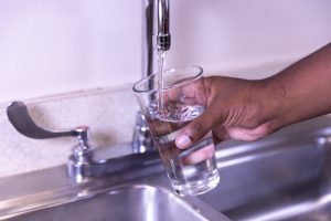 Drinking water from a kitchen faucet. Lead exposure from drinking tap water creates serious and sometimes irreversible health problems.