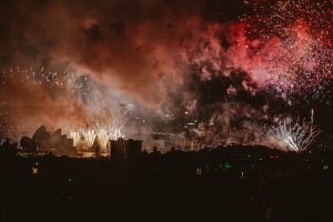 Fireworks erupt in the sky, leaving behind dense smoke