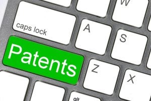 Part of a keyboard with a large key with the word “Patents” in white lettering with a green background. 