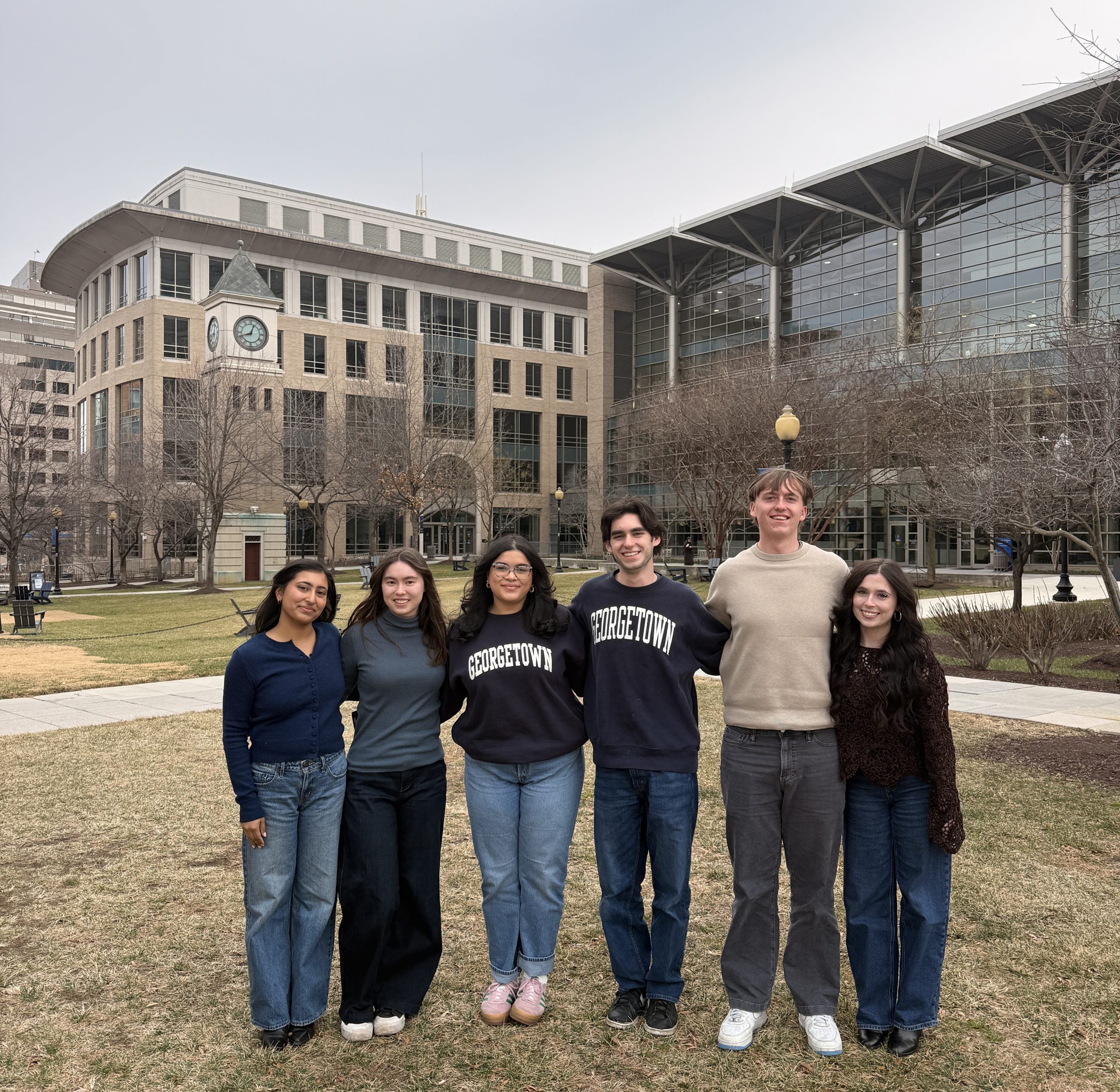 Student interns standing outside near the clocktower green