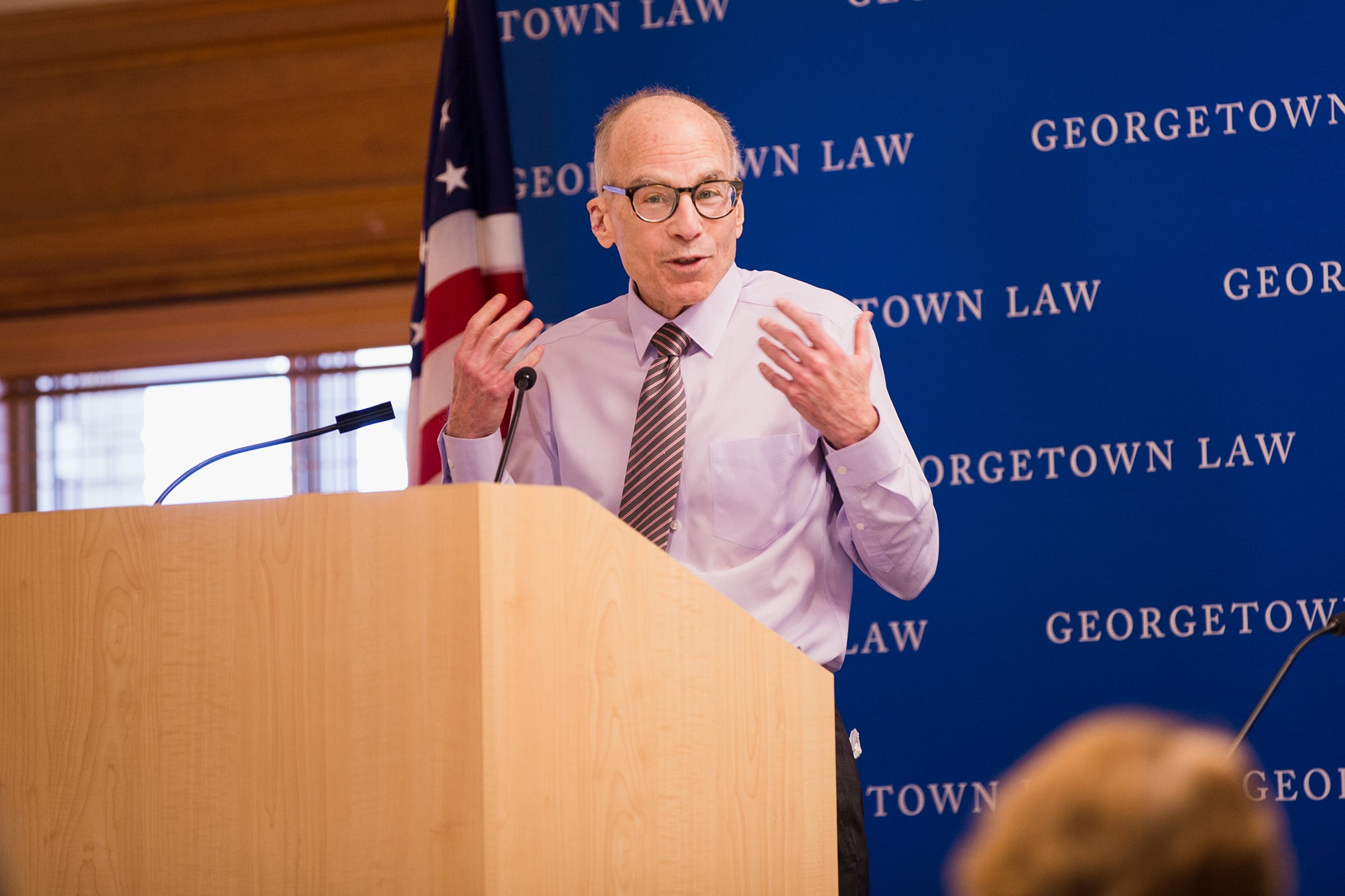 Lawrence O. Gostin at a podium speaking to the crowd.