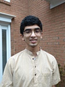 Headshot of a young man with glasses smiling