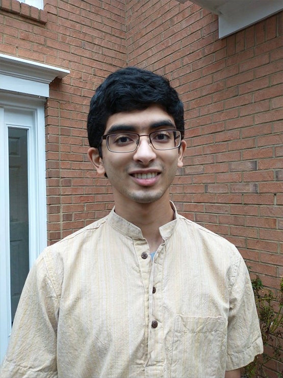 Headshot of a young man with glasses smiling