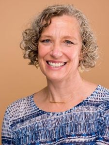 A smiling woman with short curly hair