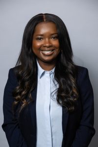 Headshot of a young woman in a button down shirt and blazer