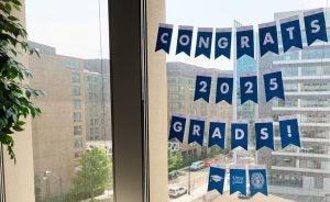 A banner hung on a window of the Tech Institute Building reads: Congrats, 2025 Grads!
