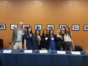 7 individuals pose for a picture after a panel.