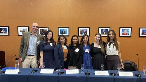 7 individuals pose for a picture after a panel.