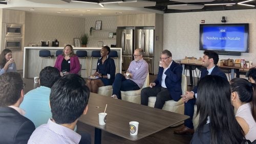 Multiple people converse sitting in a circle during Noshes with Natalie.