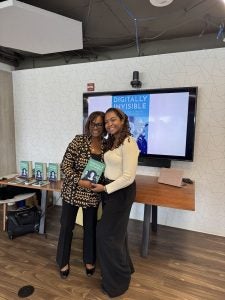 Nicol Turner Lee and Nina-Simone Edwards smile for a picture with Dr. Lee's book