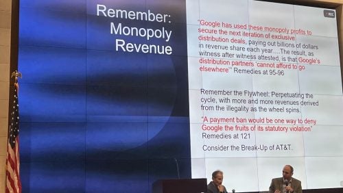 Jonathan Sallet speaks in front of a large screen, presenting about US v Google