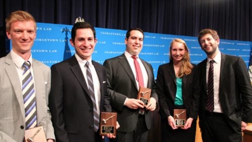 Students receive plaques and stand together for a photograph