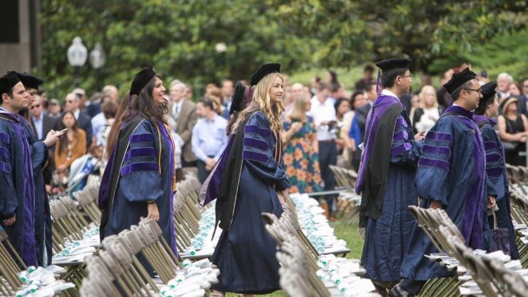 Graduates walk to take their seats on commencement day.