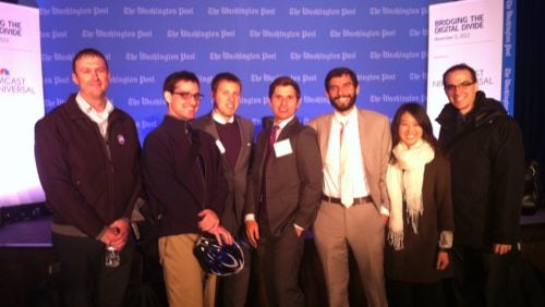 Clinical students and fellows standing in front of the stage at the Bridge the Digital Divide meeting. 