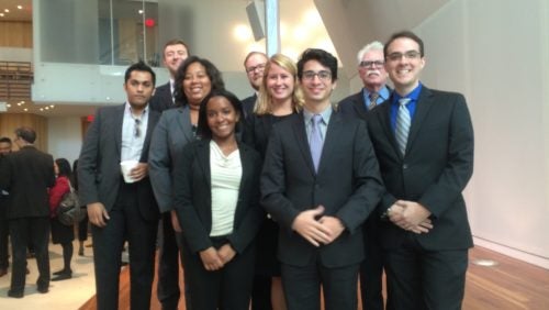 Clinical students and fellows standing in a lobby area. 