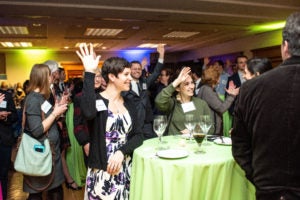 Current and former staff of the Georgetown Climate Center raise their hands.