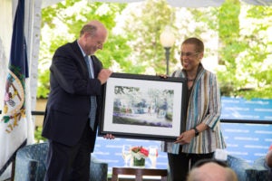 Dean William M. Treanor presents Congresswoman Eleanor Holmes Norton (H'18) with an artist's depiction of a planned bench and memorial to honor Norton, a professor at Georgetown Law for 36 years. (Rendering by Jeff Stikeman for Robert A.M. Stern Architects.)