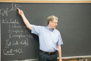 Professor Charles Abernathy teaches in front of a blackboard.