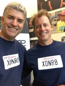 Justin Brooks (LL.M.'92) with actor Greg Kinnear, wearing sweatshirts saying "XONR8."