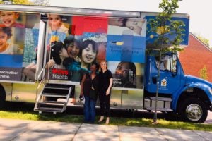 Rachel North (L'20) and her client, Ella Barnes-Williams (left), in front of the MedStar Georgetown Community Pediatrics' Kids Mobile Medical Van earlier this year. Barnes-Williams's family saw a Georgetown pediatrician and received a "legal check-up," resulting in a referral to the Health Justice Alliance Law Clinic. In Spring 2019, North helped to secure needed educational evaluations and services for Barnes-Williams's grandson.