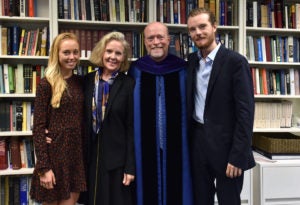 Katherine Treanor, Allison Treanor, Dean William M. Treanor and Liam Treanor in front of a bookcase in the dean's office.