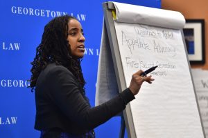 Kris Henning writing on board at Racial Justice Conference over MLK Weekend