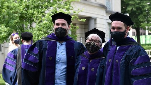 Georgetown community members gather for a photo on campus with masks during commencement week.