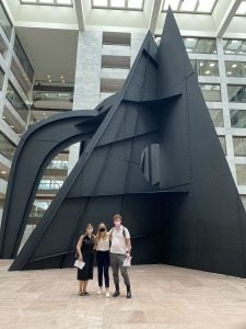 Students Alyson Raphael, Eliza Lawless, and Myles Young in front of the Mountains and Clouds sculpture in the Hart Senate Office Building