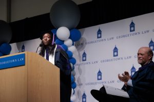 A student speaker addresses the audience at a commencement celebration