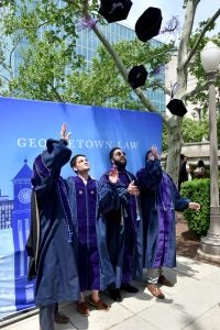 Graduating students toss their caps in the air at a commencement celebration