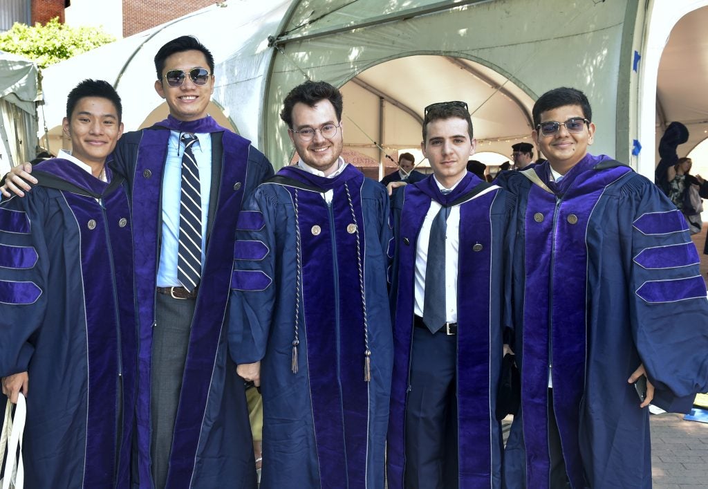 A group of graduating students stands together on Commencement Day